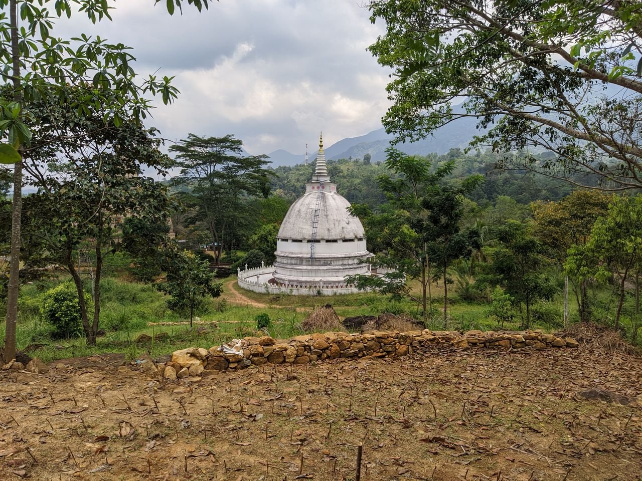 Historic Rathganga Stupa surrounded by lush greenery in Sri Lanka, showcasing Buddhist architecture.
