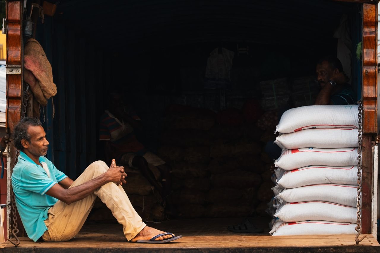 Mastering the First Impression: Your intriguing post title goes here A street vendor in Pettah, Colombo, takes a moment of rest by his goods, depicting the daily life in Sri Lanka.