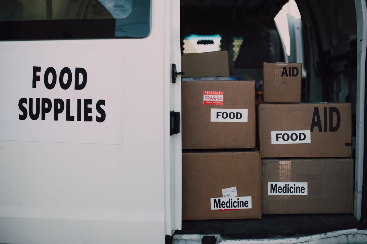 The Art of Drawing Readers In: Your attractive post title goes here Stacked donation boxes labeled food and medicine in a delivery van for charity aid.